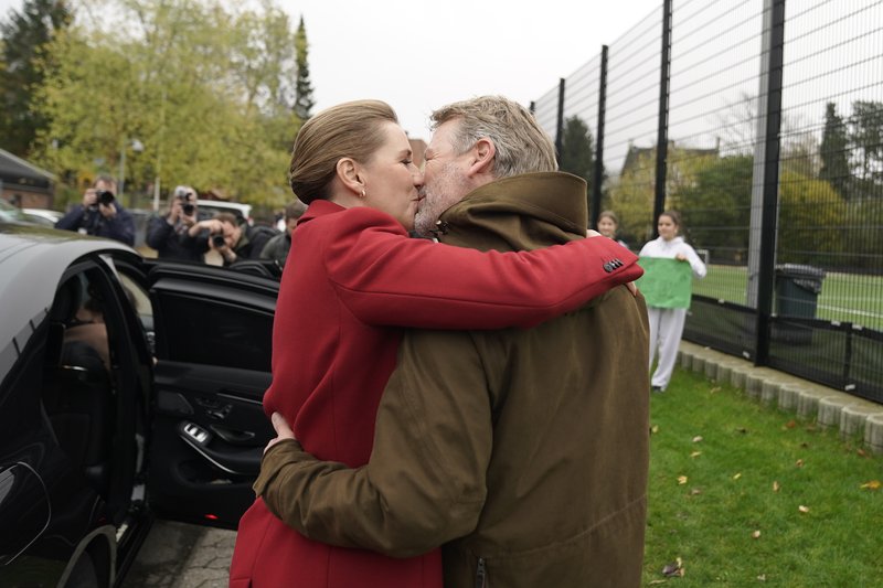 Mette Frederiksen forsætisráðherra kyssir eiginmann sinn fyrir utan kjörstað í morgun. Mynd: EPA