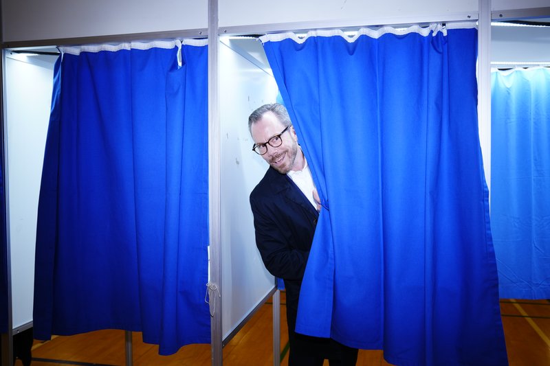 Jakob Ellemann-Jensen gægist út úr kjörklefanum í morgun. Mynd: EPA