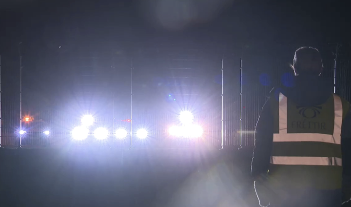 Fjögur ökutæki lýsa hér á myndatökumann RÚV, sem var að reyna að ná fréttamyndum af aðgerðum yfirvalda á Keflavíkurflugvelli.