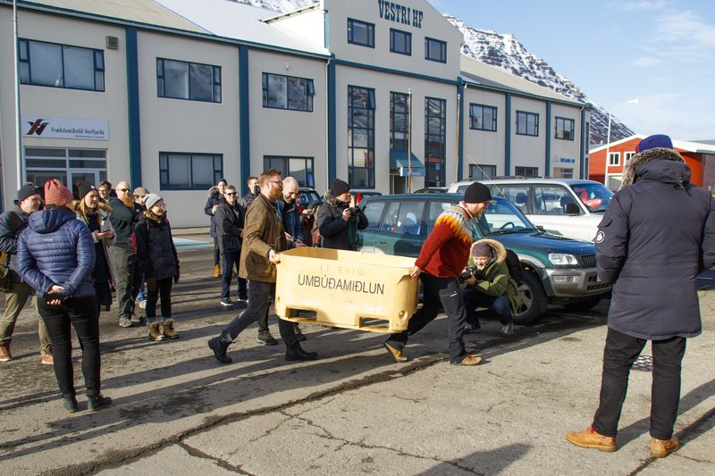 Það þurfti svið undir bæjarstjórann þegar hann átti að svipta hulunni af breyttu götuskilti við Suðurgötu á Ísafirði. Örn Elías og Ásgeir Höskuldsson, hjá ferðaþjónustufyrirtækinu Vesturferðum, voru fljótir til og sóttu fiskikar í nærliggjandi vinnslustöð.