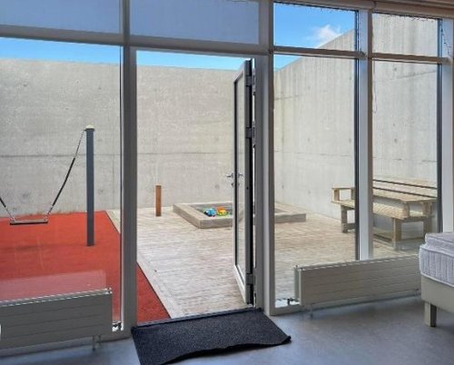 Útisvæðið við íbúðina í fangelsinu á Hólmsheiði. Girt af með steyptum og háum vegg.