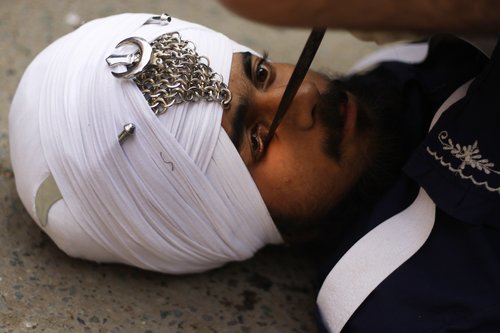 Shiki ber á sig „kajal“ með sverði á trúarhátíð. Mynd: EPA