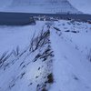 Horft niður með eystri leiðigarðinum yfir farveg snjóflóðsins úr Skollahvilft sem rann út höfnina við Flateyri. Sjá má hvernig flóðið hefur brotið gróður þegar það streymdi með garðinum. Ummerki um skriðstefnu flóðsins meðfram toppi garðsins má sjá í snjó