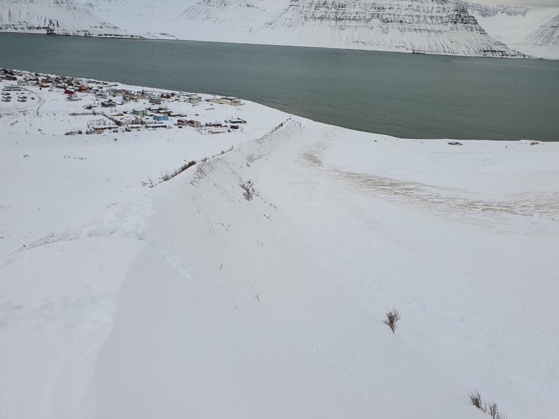 Horft niður með vestari leiðigarðinum yfir farveg snjóflóðsins úr Innra-Bæjargili sem rann út sjó vestan Flateyrar og að hluta yfir garðinn og á húsið að Ólafstúni 14.