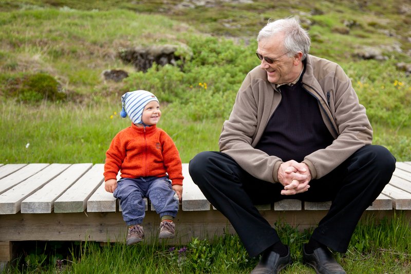 Þórarinn situr hér og rabbar við barnabarn sitt, Ólíver Daða, á Þingvöllum.