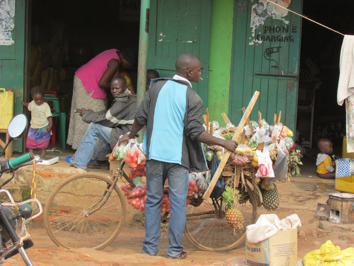 Ávaxtasali fer um götur Kampala með varning sinn á reiðhjóli.