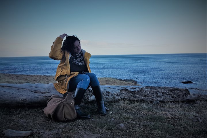 Auður Jónsdóttir rithöfundur hvílir sig á rekaviðardrumbi eftir kvöldsund í Krossneslaug á Ströndum.