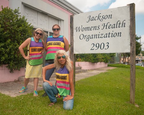 „Pink House Defenders“ vernda konur sem leita til heilsugæslustoðvarinnar frá aðkasta mótmlenda. Mynd: Twitter