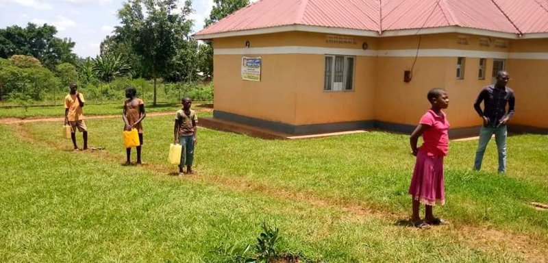 Börn úr nágrenni skólans sækja vatn í brunninn á skólalóðinni. Brunnurinn var byggður með styrk frá Utanríkisráðuneyti Íslands.