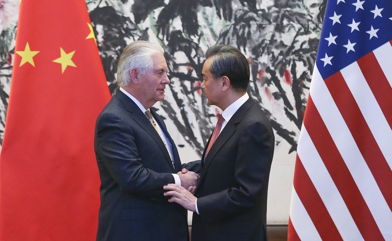 Rex Tillerson, utanríkisráðherra Bandaríkjanna, tekur í höndina á Wang Yi, utanríkisráðherra Kína, í Peking á laugardag.