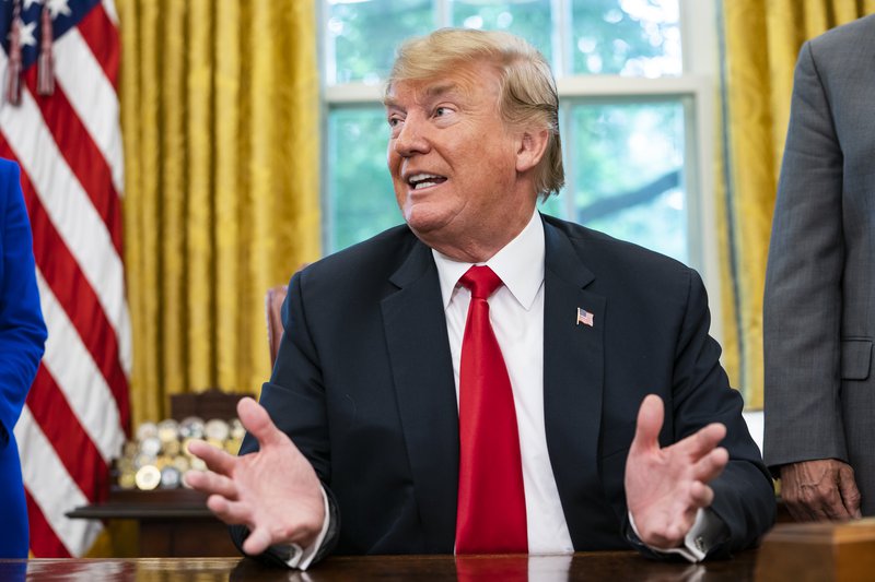 Donald Trump blés til viðburðar er hann skrifaði undir tilskipun um að afnema heimildir til að sundra fjölskyldum við landamærin. Heimild sem hann hafði sjálfur leitt í lög. Aðskilnaðurinn hélt þó áfram. Mynd: EPA