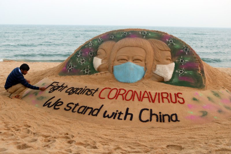 Indverji gerir listaverk úr sandi þar sem boðskapurinn er samstaða með fórnarlömbum kórónaveirunnar.