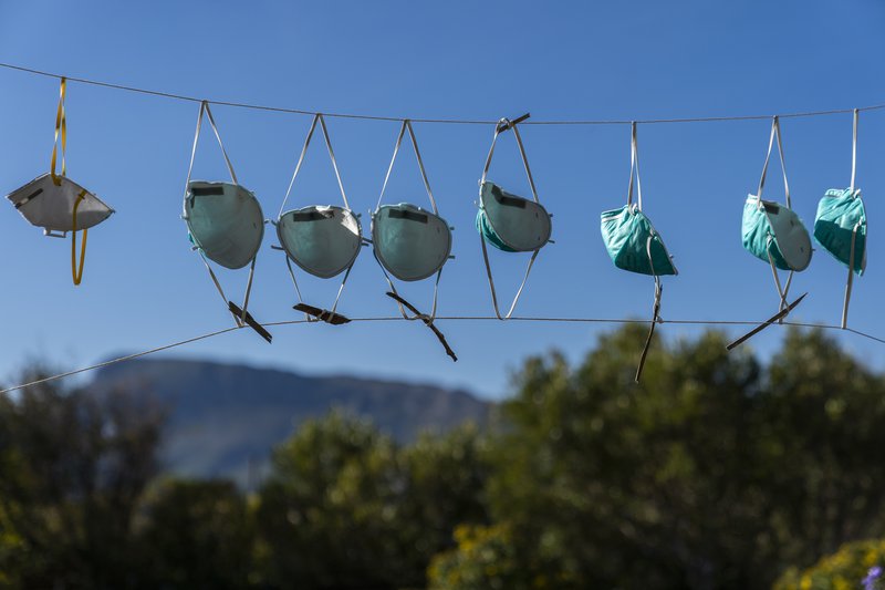 Andlitsgrímur hanga til þerris á snúru í Höfðaborg í Suður-Afríku. Það búa ekki allir við það að geta fengið nýjar grímur þegar á þarf að halda. Mynd: EPA