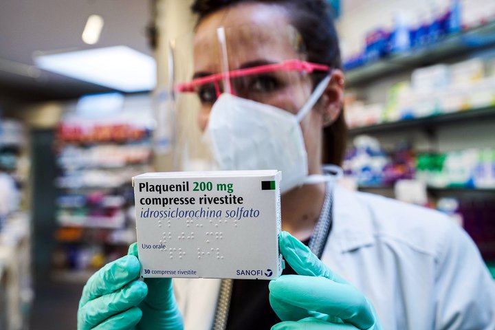 Lyfjafræðingur í Tórínó á Ítalíu með pakkningu af Pasquenil, nýju lyfi byggðu á hydroxychloroquine. Pasquenil hefur verið dreift í apótek og geta COVID-smitaðir fengið lyfið heim til sín.