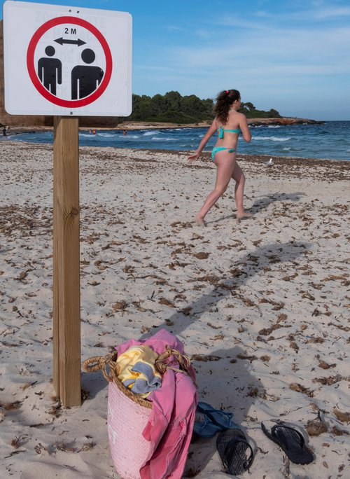 Halda á tveggja metra reglu á ströndinni á Mallorca. Mynd: EPA