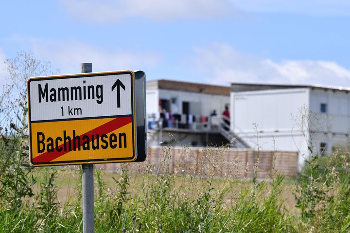 Verkamennirnir standa fyrir utan vinnubúðir sínar við grænmetis-  og ávaxtabýlið. Þar eru þeir allir í einangrun eða sóttkví.