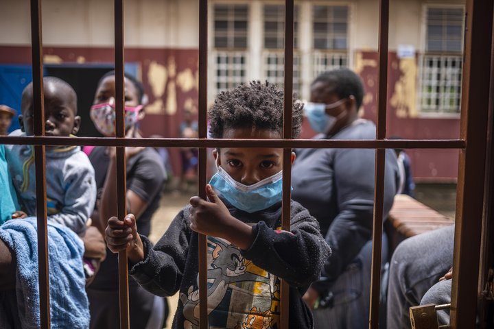 Ungur drengur bíður eftir mataraðstoð í Jóhannesarborg. Útbreiðsla faraldursins í Suður-Afríku hefur valdið því að öll þjónusta er í hægagangi.