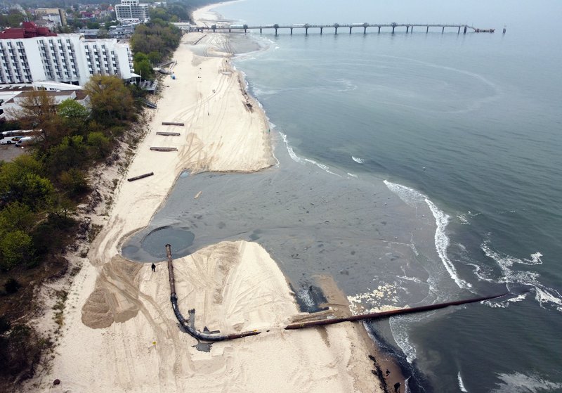 Verið er að stækka strönd Norðvestur-Póllands til að koma þar fyrir fleiri sóldýrkendum. Sandurinn í verkið er fenginn af botni Pomeranian-flóa í Eistrasalti. Mynd: EPA