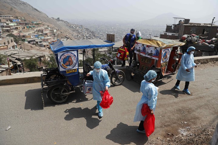 Heilbrigðisstarfsmenn í Perú fá far með litlu leigubílunum upp í fjöllin með bóluefni í farteskinu.