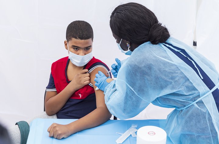 Ungur karlmaður fær bólusetningu í New York.