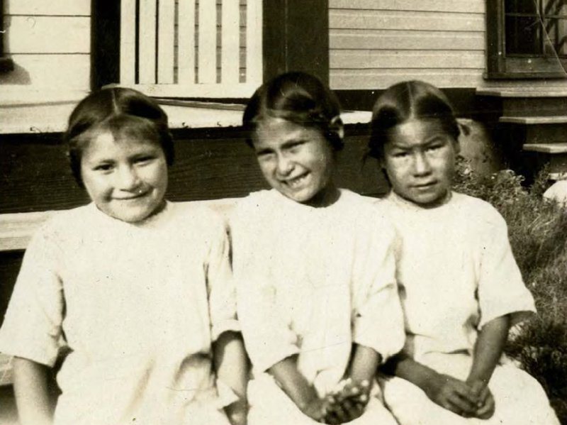 Þrjár stúlkur fyrir utan einn heimavistarskólann fljótlega eftir aldamótin 1900. Mynd: EPA