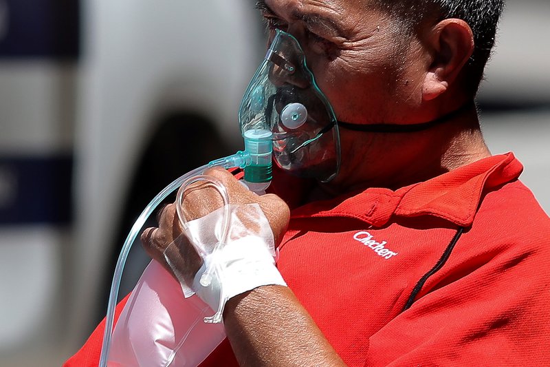 Karlmaður fær súrefni fyrir utan sjúkrahús í Hondúras. Fjöldi smita eykst hratt í landinu. Mynd: EPA