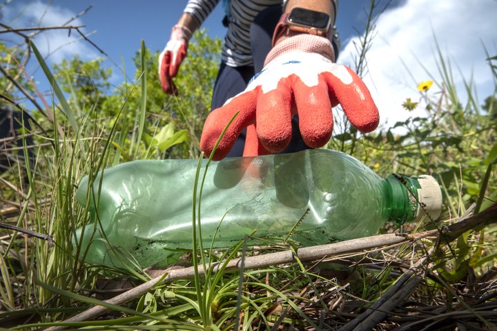 Sjálfboðaliði tínir upp plastflösku í fenjunum í Miami í Flórída.