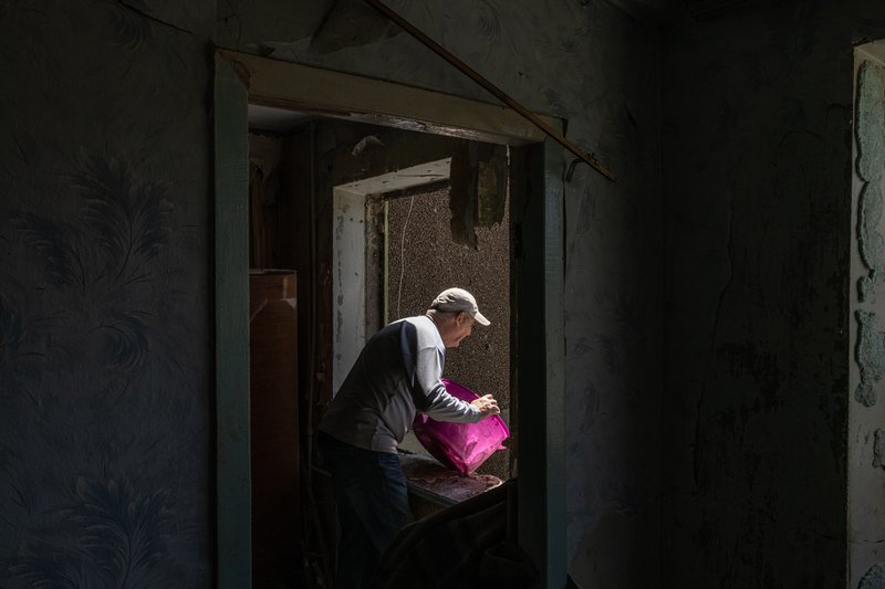 Eldi maður pakkar niður í tösku áður en hann flýr íbúð sína undan sprengjuregni Rússa. Mynd: EPA