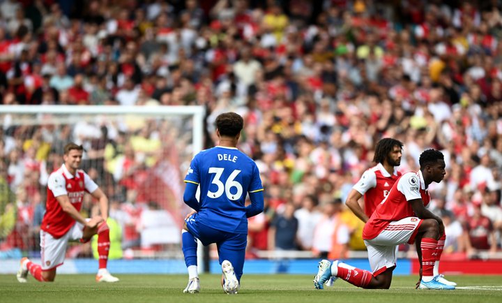 Enski knattspyrnumaðurinn Dele Alli sem leikur með Everton er hér á hnjánum ásamt þremur leikmönnum Arsenal.