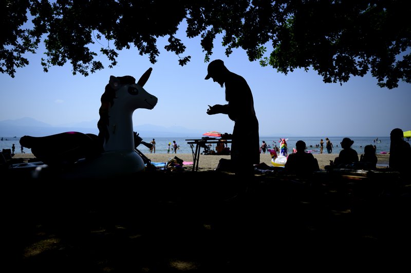 Hitinn var hæstur í gær, sunnudag, í Sviss. Fólk leitaði skiljanlega í skuggann til að verjast honum. Mynd: EPA