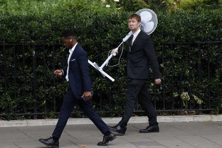 Þessi maður gekk um Westminister með viftu á öxlinni fyrr í vikunni og er því væntanlega ekki einn af þeim fjölmörgu sem hafa keypt viftur í netverslun Aldi. Sala fyrirtækisins á viftum hefur rúmlega fimmtíufaldast í aðdraganda hitabylgjunnar í Bretlandi.