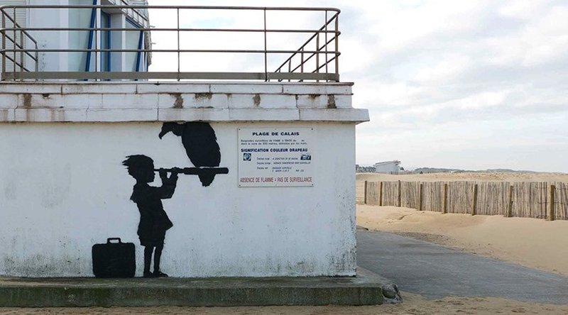 Mynd af ungri stúlka horfir yfir hafið í átt til Englands.