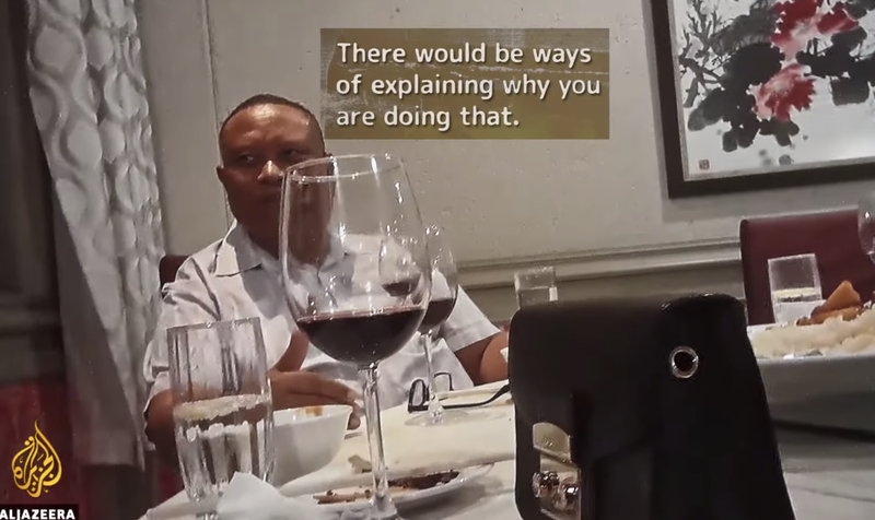 Bernhard Esau, fyrrverandi sjávarútvegsráðherra, spjallar um greiðslur á fundi. Mynd: Skjáskot/Al Jazeera