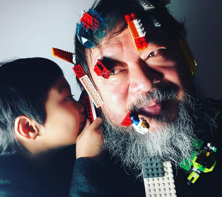 Ai Weiwei hefur birt nokkrar myndir af sér á Instagram-síðu sinni þar sem barn sést kubba á honum andlitið.